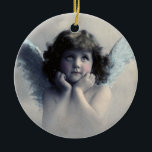 Ornamento De Cerâmica Doce Vintage Angel Christmas<br><div class="desc">Linda design de vintage de um doce anjo de Natal com asas brancas e brancas suaves e bochechas rosadas, segurando seu rosto em suas mãos. Parecendo tranquilo e gentil. O fundo está cheio de nuvens etéreas macios. O verso tem uma textura vintage desbotada com texto que diz Natal 2014 e...</div>