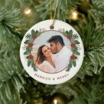 Ornamento De Cerâmica Elegante Floral 2 Foto casada Primeiro Natal<br><div class="desc">Celebre o seu primeiro Natal juntos e crie um tesouro com este belo ornamento fotográfico! Apresenta verde de inverno desenhado à mão e flores em cores rústicas de vermelho de tijolo e vários tons de verde sobre um fundo de marfim. Fácil de personalizar, com modelos de fotos e texto na...</div>