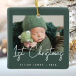 Ornamento De Cerâmica Foto: O Primeiro Livro Verde do Bebê<br><div class="desc">Celebrar o primeiro Natal do bebê com este moderno ornamento minimalista de manutenção de fotos. O texto branco lê "Natal de 1rua" num guião de caligrafia sobre um fundo verde escuro. Substitua facilmente a imagem de exemplo pela sua foto favorita e adicione o nome do bebê e o ano abaixo....</div>