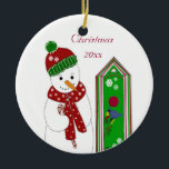 Ornamento De Cerâmica Jolly Snowman e Bird House<br><div class="desc">Um boneco de neve alegre num chapéu verde e vermelho e cachecol. Ele tem uma bengala doce. Uma casa festiva de pássaros com um pássaro azul na varanda. Personalizar com ano ou alterar mensagem conforme desejado.</div>