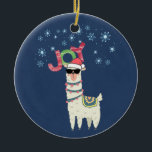 Ornamento De Cerâmica Legal Llama em Santa Hat com flocos de neve no Nat<br><div class="desc">Um ornamento com uma ilustração engraçada. Uma lhama bonita vestindo óculos escuros e um chapéu de Papai Noel vermelho. Também vestindo um cobertor sul-americano chamado "pom-poms". A palavra Joy escrita sobre sua cabeça em uma fonte festiva colorida. Flocos de neve azuis caindo. Colocado sobre um fundo azul. Design de Natal...</div>