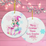 Ornamento De Cerâmica Natal vintage Elf Girl a rosa<br><div class="desc">Bonito Enfeites de natal personalizado com um elfo retro-feminino fofo em um chapéu cor-de-rosa cercado por flocos de neve rosas e azuis. O verso pode ser personalizado com uma mensagem personalizada.</div>