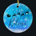 Ornamento De Cerâmica Papai Noel e sua Rebelde Voadora - Acredite<br><div class="desc">O ornamento temático do Natal com uma silhueta preta de papais noeis cavalgando em seu trenó sendo puxado por sua rena voando pelo céu. Acredite que está escrito em uma fonte de script vermelho de tendência. O fundo é um design de floco de neve gelado azul gelado.</div>