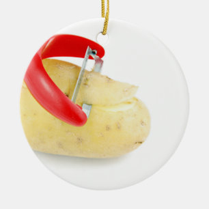 Ornamento De Cerâmica Peeler vermelho que corta a batata no fundo branco