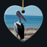 Ornamento De Cerâmica Pelican On Beach Rock,<br><div class="desc">Apresentado em uma rocha de praia perto do oceano é um pelicano faminto e bonito esperando por mariscos-pesadelos.</div>