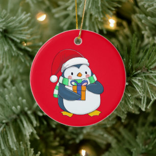 Ornamento De Cerâmica Pinguim num chapéu de Natal com um presente