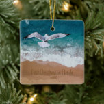 Ornamento De Cerâmica Sand Escrevendo Beach Nosso Primeiro Natal na Flór<br><div class="desc">O ornamento personalizado da praia de areia escrevendo da Boutique Co. náutica apresenta uma pintura aquarela da praia com o gaivoso sobrevoando e seu escrevendo personalizado na areia. "Primeiro Natal na Flórida" pode ser personalizado e, é claro, o ano pode ser mudado também. O verso apresenta a(s) sua(s) foto(s) favorita(s)...</div>