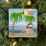 Ornamento De Cerâmica Santa Claus Sandman Na Praia Tropical<br><div class="desc">Homem de areia bonito vestindo um chapéu de Papai Noel na areia da praia com luzes de férias nas palmeiras. O texto pode ser alterado ou excluído.</div>