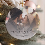 Ornamento De Cerâmica Script de Cinza de Fotografias Personalizadas Envo<br><div class="desc">Comemore o seu noivado com este belo ornamento moderno do keepsasaame. O texto da cinza de carvão diz "Nosso primeiro Natal engajado", com a palavra "engajado" em escrita elegante com baloiços antes e depois. Substitua a imagem de exemplo por sua foto favorita e adicione seus nomes e o ano. Um...</div>