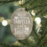 Ornamento De Cerâmica Seja um viajante e não uma citação tipográfica do<br><div class="desc">Comemore um ano de viagem com nosso ornamento de citação tipográfica! Design apresenta a citação, "Seja um viajante, não um turista" em tipografia monolónica branca enfeitada com duas ilustrações de seta, sobre um fundo de uma pintura de tom sepia vintage 1708 no mapa mundial. Personalize as costas com o ano....</div>