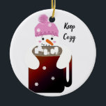 Ornamento De Cerâmica Snowman a abraçar uma caneca de chocolate quente<br><div class="desc">Fique confortável. Este bonitinho bonitinho vai fazer você sorrir enquanto ele abraça esta caneca de chocolate quente para ficar quente!</div>