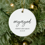 Ornamento De Cerâmica Sydney First Christmas Engaged Modern<br><div class="desc">Enfeites de natal moderno com um design tipográfico contemporâneo com "engajado" em tipografia de script elegante junto com seus nomes e data de noivado em um layout simples e mínimo. As costas têm sua foto favorita. O tema de cores é preto e branco e pode ser alterado na ferramenta de...</div>