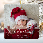 Ornamento De Cerâmica White Script de Foto de Natal dos Avós<br><div class="desc">Ajudem-nos a celebrar o seu primeiro neto com este belo ornamento moderno do keepsasawn. O texto de fora do preto diz "Nosso primeiro Natal como avós", com a palavra "avós" em um roteiro elegante, com flores antes e depois. Substitua facilmente a imagem de amostra pela sua foto favorita do novo...</div>