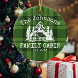 Ornamento De Cerâmica Xadrez Verde de Cabina da Família Nome Personaliza<br><div class="desc">Ideal para encontros familiares, reuniões, ou para o retiro da montanha, este produto foi projetado com um charmoso fundo de xadrez verde. Mostra uma cena de montanha maravilhosamente projetada com cabana cercada por árvores, personalizada com seu nome familiar, o ano estabelecido e quaisquer detalhes adicionais que você preferir. Uma excelente...</div>