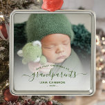 Ornamento De Metal Avós Primeiro Foto de Natal - Script Verde<br><div class="desc">Ajudem-nos a celebrar o seu primeiro neto com este belo ornamento moderno do keepsasawn. O texto verde lê "Nosso primeiro Natal como avós", com a palavra "avós" em elegante manuscrito com flores antes e depois. Substitua facilmente a imagem de amostra pela sua foto favorita do novo bebê, e adicione o...</div>