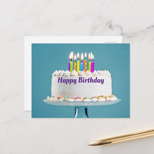 Postal Cartão de Aniversário de Bolo (A beautifully decorated birthday cake with colorful candles lit on top, set against a soft blue back)