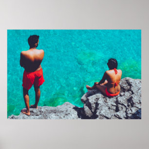 Poster Homem e mulher sentados em pedra perto do corpo de