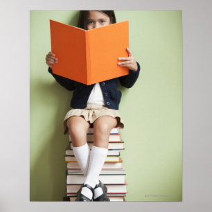 Poster Menina da raça misturada que senta-se na pilha de