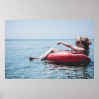 Mulher em um flutuador inflável no oceano apontand