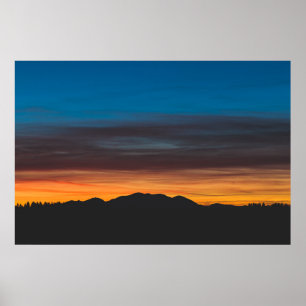 Poster Queimando o pôr do sol acima da silhueta paisagíst