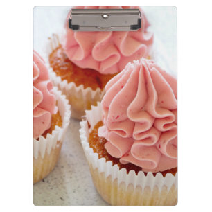 Pranchetas Um Cupcake doce de tratamento com Glacé rosa