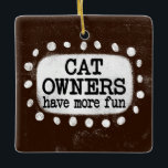 Proprietários De Gatos Têm Mais Ornamento Divertid<br><div class="desc">"Proprietários de Gatos Se Divertem Mais" é um design de texto giro em castanho com texto preto,  junto com uma forma de sotaque branco e pontos brancos texturizados ao seu redor.</div>
