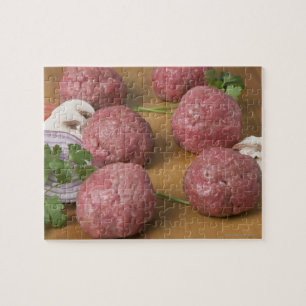 Quebra-cabeça Meatballs crus em um conselho de corte