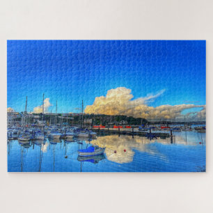Quebra-cabeça Reflexos de Brixham: Nuvens Douradas e Vista para