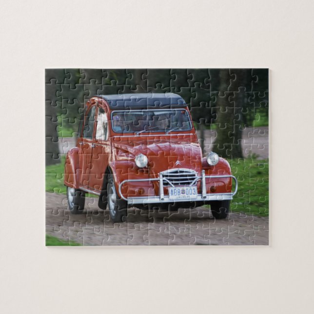 Quebra-cabeça Um velho Citroen 2CV vermelho com uma mulher sorri (Horizontal)