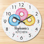 Relógio Grande Cozinha rosquinha Personalizada<br><div class="desc">Este relógio divertido é decorado com três rosquinhas em azul, rosa e amarelo sobre um fundo de aspersão. Facilmente personalizável com seu nome. Use a opção Personalizar mais para alterar o tamanho, o estilo ou a cor do texto, se desejar. Porque nós criamos nosso próprio trabalho de arte você não...</div>