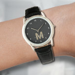 Relógio Monograma Elegante Moderno Preto Dourado<br><div class="desc">Relógio Preto e Branco Personalizado com Monograma e Números Brancos Simples. Este relógio elegante e minimalista combina estilo clássico com um toque pessoal, apresentando uma inicial ousada em dourado (nota: o dourado é uma cor plana sem brilho) em um mostrador preto, acentuado por números brancos simples para fácil leitura. O...</div>