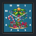 Relógio Quadrado Árvore Tropical de Palma de Natal<br><div class="desc">Um relógio com uma imagem de feriado sazonal. Uma palmeira tropical decorada em luzes festivas com uma estrela no topo. Uma bengala branca e vermelha gigante que sai da areia. Presentes de Natal debaixo da árvore. Whimsical e divertido.</div>