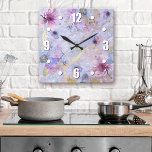 Relógio Quadrado Cor de água floral azul romântica vítrea<br><div class="desc">Números brancos, de fácil leitura, negros, juntamente com flores brancas, roxas e azuis de cor d'água, sobrepõem o script branco em um plano de fundo brilhante, azul púrpura e ouro, de cor branca. Dê vida ao seu quarto favorito com este relógio de na moda, incrível. A tua escolha de um...</div>