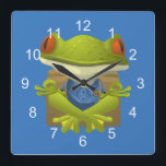 Relógio Quadrado Sapo Meditating engraçado<br><div class="desc">Um design meditating engraçado dos desenhos animados do sapo. Você pode mudar o fundo azul à cor de sua escolha usando "personaliza-a" opção.</div>