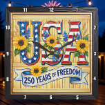 Relógio Quadrado USA 250 Years Freedom Sunflower<br><div class="desc">Celebrate a historic quarter-millennium with the "250 Years of Freedom" Sunflower clock. This high-energy timepiece features a high-definition graphic that blends patriotic pride with natural beauty. The design centers on bold, stylized "USA" lettering filled with stars and stripes, prominently accented by vibrant, sun-drenched sunflowers and blue wildflowers. A graceful white...</div>