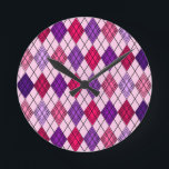 Relógio Redondo Art Deco Argyle<br><div class="desc">Este relógio de parede tem um design de deco de arte de formas de diamante feitas de ângulos sobrepostos em linhas pretas coloridas em tons roxos e cor-de-rosa com linhas pretas diagonais fazeres a design parece argyle</div>