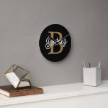 Relógio Redondo Nome do Monograma Elegante Moderno Script Dourado<br><div class="desc">O Relógio de Script Dourado Preto do Nome Elegante Moderno é um na moda e um relógio personalizado perfeito para qualquer configuração de casa ou escritório. Este relógio apresenta uma face preta elegante com um guião de ouro elegante, permitindo-lhe personalizá-lo com o seu monograma e nome. O design moderno e...</div>