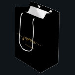 Sacola Para Presentes Média Monograma Feminino Simples Minimalista Preto Doura<br><div class="desc">Saco de presente personalizado feminino minimalista simples e limpo com monograma em preto e dourado. Este design apresenta seu primeiro nome em uma linda tipografia de letra manuscrita com rabiscos (ou caligrafia) com o texto "DAMA DE HONRA" em fundo preto e dourado. São fáceis de personalizar. Esta bolsa de presente...</div>