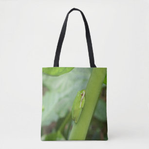 sapo verde brilhante em uma bolsa de tote