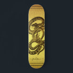Skate Cobras Personalizados Folha de Papel Ouro<br><div class="desc">Um skate exclusivo com dois cobras enredados e seu nome personalizado em uma assinatura de script em um fundo falso de folha de ouro. captura de olhos e negrito.</div>