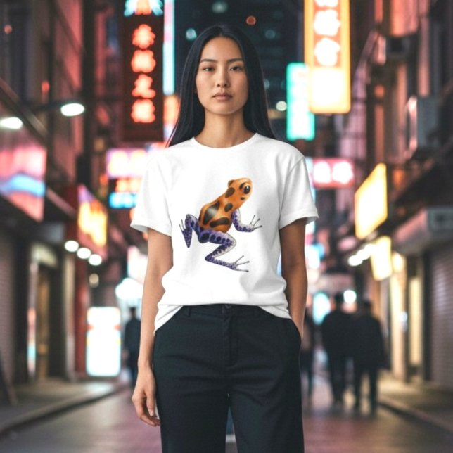T-shirt Sapo Veneno (A vibrant orange and blue poison dart frog on a classic white tee, on a woman in the city at night.)
