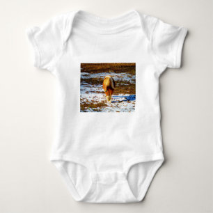 T-shirts Cavalo marrom e minúsculo creme na neve.
