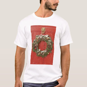 T-shirts Grinalda do Natal que pendura em uma porta