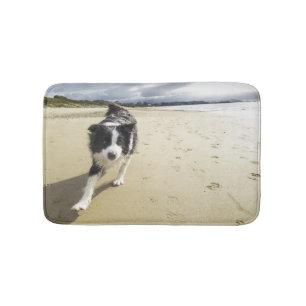 Tapete De Banheiro Um cão de border collie que funciona na praia