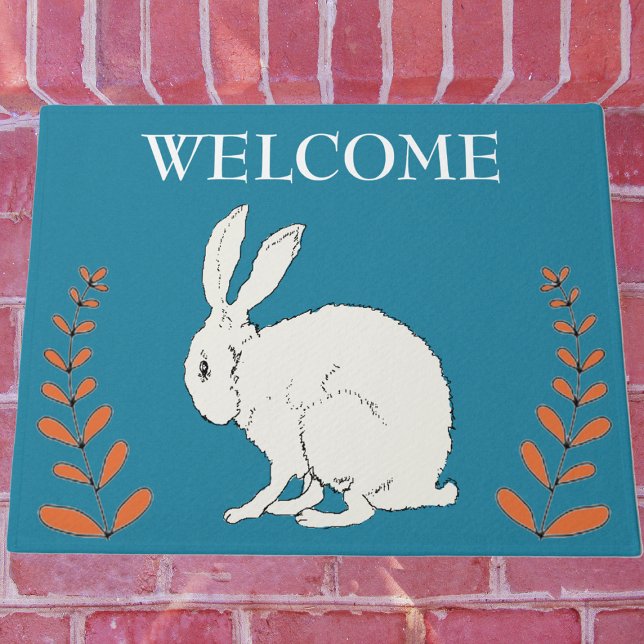 Tapete Elegante Sentado Coelho Branco Plantas Laranja em  (White sitting rabbit with tall orange plants on dark blue Welcome outdoor mat.)