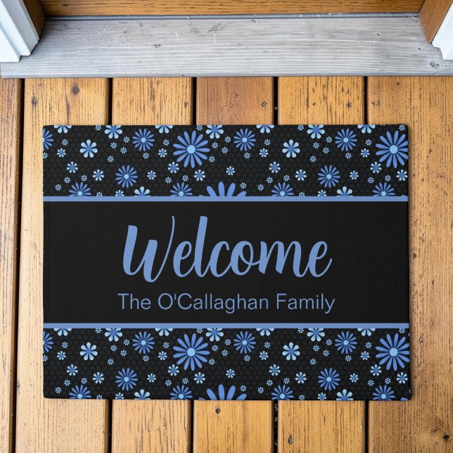 Tapete Poder Floral Azul e Preto Floral Retro (A blue retro daisy pattern in a moody, modern aesthetic on a custom welcome mat, placed on a deck.)