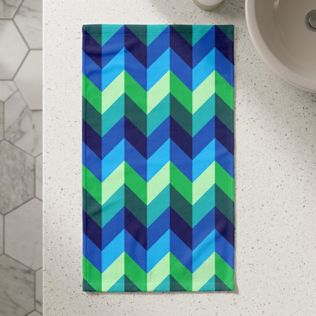 Toalha de mão com ombre chevrons azul verde (Top down view of Blue Green Ombre Chevrons Hand Towel on a counter in a modern style bathroom.)
