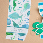 Toalha De Praia Monograma branco de golfinhos-do-mar verde-azul<br><div class="desc">Sob o mar, tema oceânico. Um fundo branco-quic com um padrão aquoso de vida marinha, peixes, golfinhos, uma baleia, tartaruga, cavalo-marinho, água-viva em verde, azul e lacrimogêneo. Perfeito para uma casa de praia ou uma casa de verão. Personalize e adicione seu nome. O nome é escrito com um roteiro escrito...</div>
