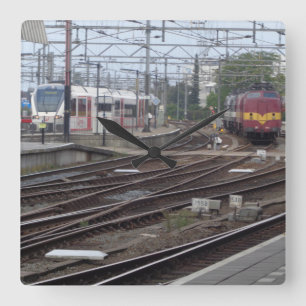 Trens de passageiros que chegam ao relógio da esta