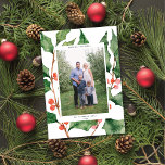Watercolor Holly   Berries Holiday Cartão com foto<br><div class="desc">Este cartão com fotos de Natal moderno apresenta um fundo de aquarela pintado de folhas e bagas sagradas. A saudação na frente do cartão diz "Feriados mais felizes" em uma fonte sans serif moderna, ele pode ser personalizado com seu próprio texto. Este design acomoda uma foto vertical do solteiro na...</div>